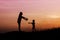 Silhouettes of mather and little daughter walking at sunset