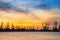 Silhouettes of mechanical cranes and industrial cargo ships in sea port on the background of sunset