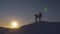 Silhouettes of men descending from high snowy mountain seeking adventure in glare of setting sun in winter. Concept of