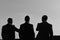 Silhouettes of men standing against sunset. Leaders discuss project.