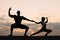 Silhouettes of mixed couple gymnasts dancing on sunset. Grace and beauty of human\'s body