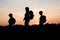 Silhouettes of mom hiking with her kids at sunset