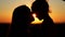 Silhouettes of mother and her daughter heads. Mom kissing her child.