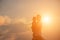 Silhouettes of mother and little daughter walking at sunset