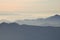 Silhouettes of mountains in the fog at sunset