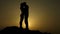 Silhouettes of newlyweds couple kissing passionately, romantic love story