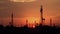 Silhouettes of oil derricks taking oil at dusk with the sun in the background. AI generated