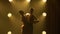 Silhouettes of a pair of dancers performing elements of Argentine dance appear against the smoky yellow background of