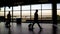 Silhouettes of passengers walking at terminal hall, business trip, airport