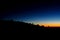 Silhouettes of people ant tents in the mountains at sunset light