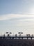 Silhouettes of people on the bridge on the seashore. People see off the sunset. Sea coast. Pier on the sea