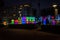 Silhouettes of people having fun at night while posing in front of cubes illuminated with different light colours in Chavasse Park