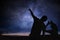 Silhouettes of people observing stars in night sky. Astronomy concept