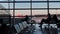 Silhouettes of people sitting in the airport lounge before departure. Airplanes stand behind the glass. panoramic camera