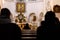 Silhouettes of people sitting in the temple. Service in the catholic church. Dark blurry silhouettes of praying believers. Focus