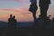 Silhouettes of people standing on the hill watching city on suns