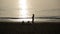 Silhouettes of people standing at sunset by the sea. woman and children