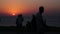 Silhouettes of people on the street. Sunset at the sea. Looped video.