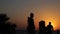 Silhouettes of people on the street. Sunset at the sea. Looped video.