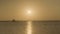 Silhouettes of people walking along the pier, evening sunset in the sea