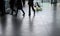 Silhouettes of people walking backlight on a polished pavement