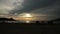 Silhouettes of people walking on the summer beach at sunset