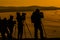Silhouettes of photographers, with their equipment , shooting a sunset