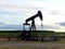 Silhouettes of a pumpjack at sunset in the field, France