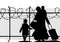 Silhouettes of refugee with two children standing at the border. Immigration religion and social theme