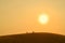 Silhouettes of sitting and talking friends on a sand hill