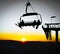 Silhouettes of skiers on chair lifts in the evening