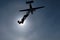 The silhouettes of skydivers and airplane in the sky.