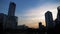 Silhouettes of skyscrapers and construction cranes at sunset. City buildings on the beautiful sky background, urban