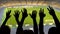 Silhouettes of soccer fans hands during match, crowded football stadium, sport