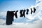 Silhouettes of socks and clothes of climbers drying on a rope high in the mountains