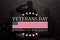 Silhouettes of soldiers saluting with text Veterans Day Honoring All Who Served on black textured background.