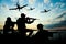 Silhouettes of soldiers in uniform with assault rifles and military airplanes patrolling