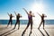 Silhouettes of sportive girls dancing near sea at sunrise.