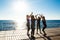 Silhouettes of sportive girls giving highfive near sea at sunrise.