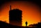 silhouettes of structures, pipes, oil storage tanks, pipelines of a petrochemical plant in the backlight of the sun at