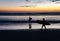 Silhouettes of surfers at sunset