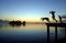 SILHOUETTES OF TEENAGERS JUMPING FROM A PONTOON INTO THE WATER WITH A FANTASTIC SKY BACKGROUND AT SUNSET. OUDOORS, PEOPLE