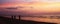 Silhouettes of three cyclists leaving along the coastline of the Baltic Sea at sunset in Jurmala