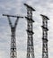 Silhouettes of three electricity pylons against evening sky