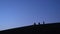 Silhouettes of Three Guys making Photo on Smartphone and Selfie on the Slope of Hill Early in the Morning with Young