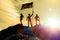 Silhouettes of three happy man on a mountain top, with flag america