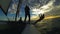 Silhouettes of three people sailing on windsurfing catamaran against sunset sky