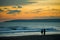 Silhouettes of three people walking on a beach a