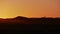 Silhouettes of tourist couple enjoying the colorful sunrise in the sand dunes of Erg Chebbi near Merzouga in Morocco, Africa.