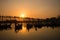 Silhouettes of tourists in boats admiring U Bein bridge over the Taungthaman Lake at sunset, in Amarapura, Mandalay Myanmar